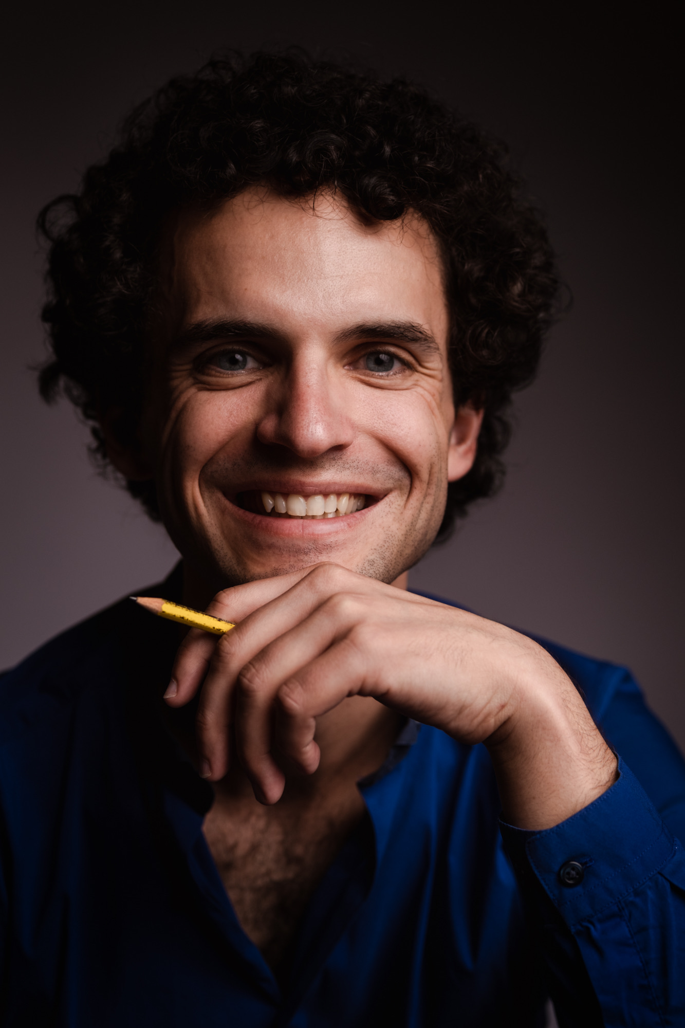 Portrait of Simon Mack holding a pen.